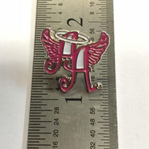 Ainsley’s Angels of America pin measured on a ruler