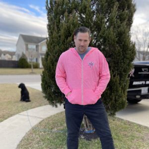 A picture of a man wearing a pink hoodie