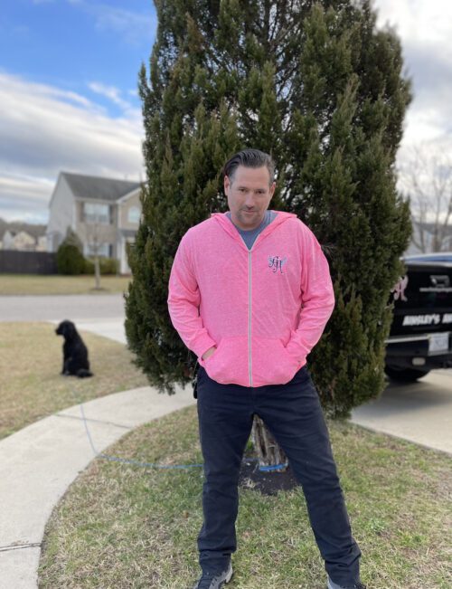 A picture of a man wearing a pink hoodie